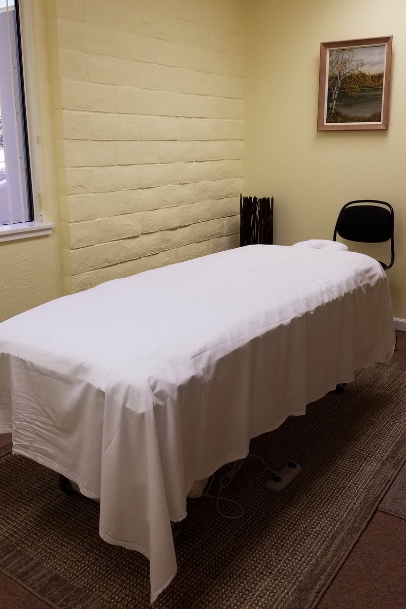 Massage room showing table, stool and painting